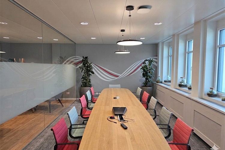 Sitzungszimmer der VP Bank Zürich mit dunkelgrauer Wandfläche, dekorativ schablonierter Negativfolie und moderner Büroeinrichtung.